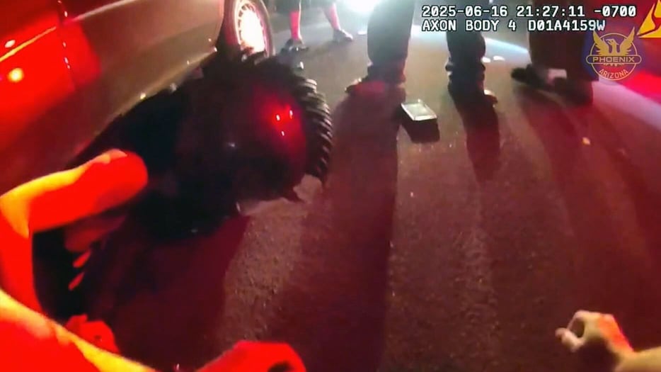 Police lift car to rescue motorcyclist pinned underneath